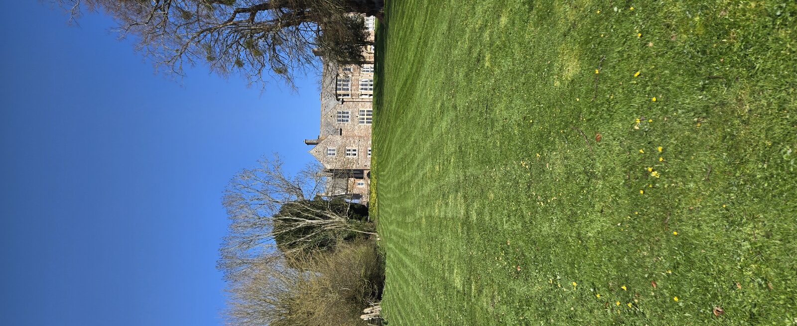 Professional grounds maintenance — striped lawn, manor house